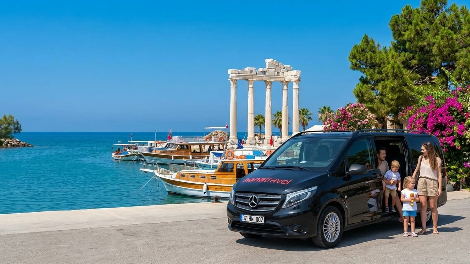 The old harbour, a few steps from the drop-off Parents and children stepping out of the black Hana Travel Vito by the old harbour of Side, fishing boats and the Temple of Apollo behind — Side taxi transfer